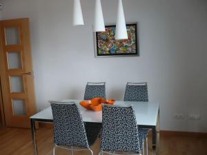 ein Esszimmer mit einem Tisch, Stühlen und einem Bild in der Unterkunft Atico, Piscina, Aire Acondicionado, WI-FI, Parking Gratis, Gran Terraza in Arroyo de la Encomienda