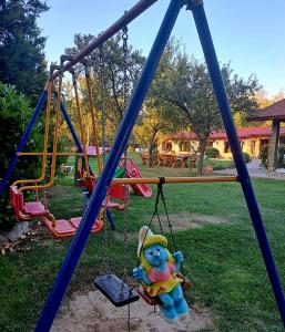 a teddy bear on a swing at a playground at Pensiunea Casa Noastra in Baia de Fier
