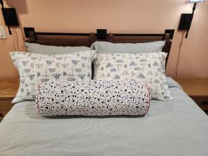 ロックポートにあるThe Orca Suite- Bearskin Neck Rockport- Steps to allの枕が4つとバッグが置かれたベッド