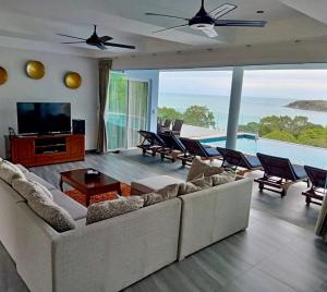 a living room with a couch and a tv at IslandView Villa in Choeng Mon Beach