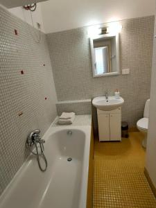 een badkamer met een wit bad en een wastafel bij Kazimierz/Old Town Apartment in Krakau