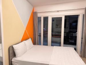 - une chambre avec un lit et une grande fenêtre dans l'établissement Moka's House, à Hô-Chi-Minh-Ville
