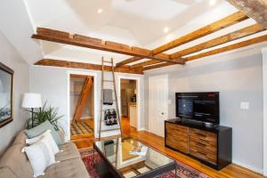 a living room with a couch and a tv at The Seabird Suite in Marblehead