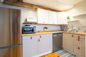 a kitchen with white cabinets and a microwave at The Seabird Suite in Marblehead