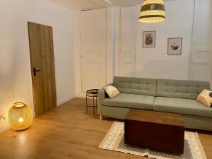 uma sala de estar com um sofá verde e uma mesa em Cosy Studio - Verneuil d'Avre et d'Iton em Verneuil d’Avre et d’Iton