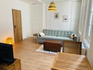 uma sala de estar com um sofá azul e uma televisão em Cosy Studio - Verneuil d'Avre et d'Iton em Verneuil d’Avre et d’Iton
