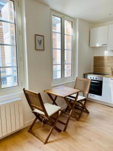 uma cozinha com uma mesa de madeira e 2 cadeiras em Cosy Studio - Verneuil d'Avre et d'Iton em Verneuil d’Avre et d’Iton