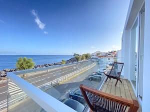 a balcony with a bench and a view of the ocean at Pedra do Mar in São Roque