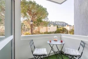 a small table and two chairs on a balcony with a window at Le Roucas - Chaleureux appartement aux Baux de Provence in Les Baux-de-Provence