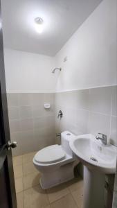 a bathroom with a white toilet and a sink at Unit 1O1 Nottingham Villas in Puerto Princesa City