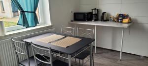 einen Tisch und Stühle in einer kleinen Küche mit einer Theke in der Unterkunft Ap 10 - 2 SZ bei Helmstedt und Oschersleben in Ausleben