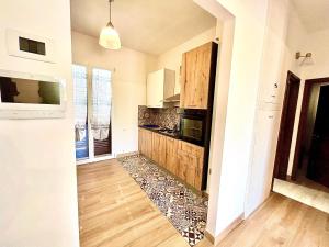 a kitchen with wooden cabinets and a stone floor at Verdura Home in Caltabellotta