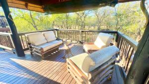 a porch with two chairs and a couch on it at Kruger Kumba - Mugwenzi in Marloth Park