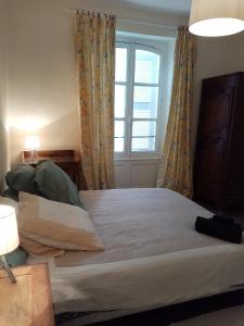 a bedroom with a large bed with a window at Maison en plein cœur de ville à Montmorillon in Montmorillon