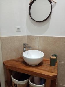 ein Badezimmer mit einem weißen Waschbecken und einem Spiegel in der Unterkunft Maison en plein cœur de ville à Montmorillon in Montmorillon + 6 Fotos