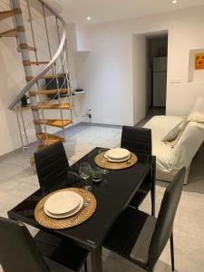 une salle à manger avec une table et des chaises noires dans l'établissement Au coeur du Village, à Cotignac