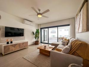 ein Wohnzimmer mit einem Sofa und einem Flachbild-TV in der Unterkunft BG2D3 Amazing apartment with private picuzzi in private terrace in Punta Cana