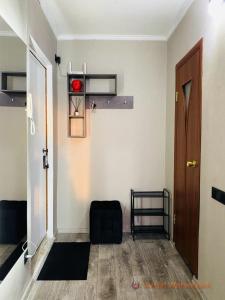 Cette chambre dispose d'un couloir avec une porte et une chaise. dans l'établissement 1-комнатная квартира, à Pavlodar