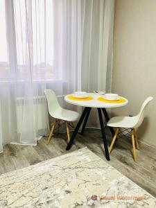 1 mesa y 2 sillas en una habitación con ventana en 1-комнатная квартира en Pavlodar