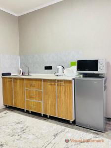 a kitchen with a sink and a microwave at 1-комнатная квартира in Pavlodar