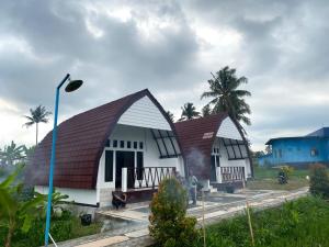 zwei Häuser mit rotem Dach in der Unterkunft D'Liwatan Bungalow in Masbagik