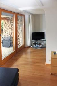 a living room with a television and a sliding glass door at B&B Hersberg in Hersberg