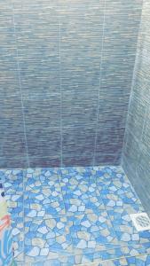 a bathroom with a shower with a tile floor at Sajaairbnb in Narok