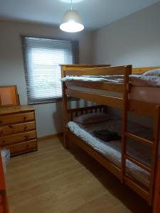 a bedroom with two bunk beds and a dresser at Ivy Cottage in Montrose