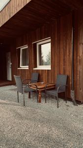 três cadeiras e uma mesa de madeira num edifício em Rudnic villa s Ap1 em Syfteland