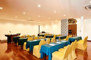 a banquet hall with blue tables and yellow chairs at Villa De Pranakorn in Bangkok