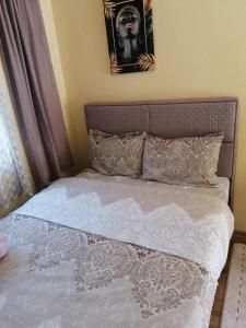 een bed met witte lakens en kussens in een slaapkamer bij Studio apartmani Anastasija in Žabljak