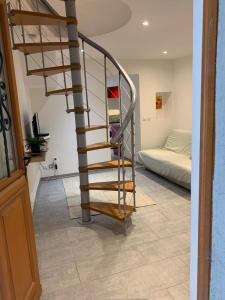 - un escalier en colimaçon dans une chambre avec un lit dans l'établissement Au coeur du Village, à Cotignac