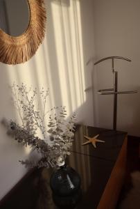 a vase with flowers on a table with a mirror at Sea View Apartment in Faro