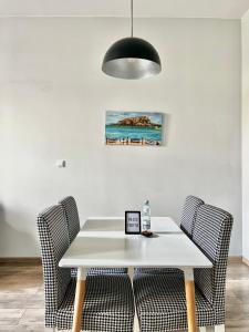 een eettafel met stoelen en een zwarte lamp bij ACM Centrum Apartament z parkingiem in Bydgoszcz