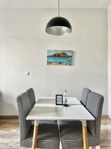a dining room table with chairs and a black light fixture at ACM Centrum Apartament z parkingiem in Bydgoszcz