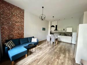 a living room with a blue couch and a brick wall at The Garbary - parking free in Bydgoszcz