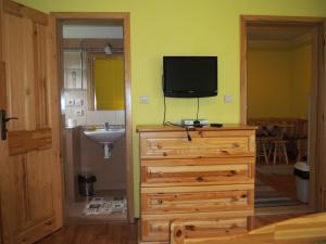 a bathroom with a sink and a television on a dresser at Privat Lubika in Trstené +37 photos