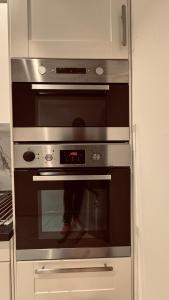 um forno de aço inoxidável numa cozinha branca em Rudnic villa s Ap1 em Syfteland