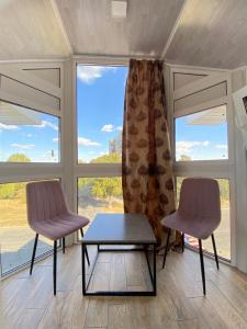 two chairs and a table in a room with a window at Hotel Chicago in Umanʼ