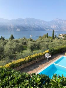 a villa with a pool and a view of the water at Appartamento Perla del Lago - Enchanting Lake View in Malcesine