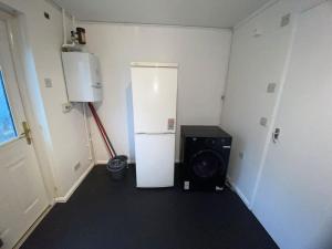 a room with a refrigerator and a washing machine at Entire 1 bedroom city house in London