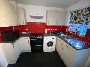a small kitchen with a washing machine in it at Entire 1 bedroom city house in London