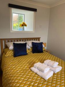 a bedroom with a bed with towels on it at Da Peerie Hoose in Hamnavoe