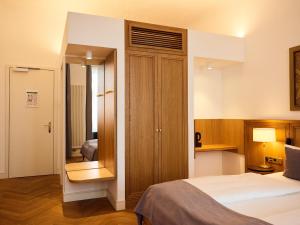 a hotel room with a bed and a mirror at Hotel Lindenufer in Berlin