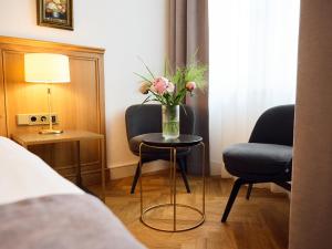 ein Zimmer mit einem Tisch mit einer Blumenvase darauf in der Unterkunft Hotel Lindenufer in Berlin