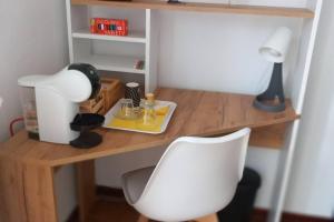 ein Schreibtisch mit einer Lampe und einem weißen Stuhl in der Unterkunft Vito's Room in Cormano + 12 Fotos