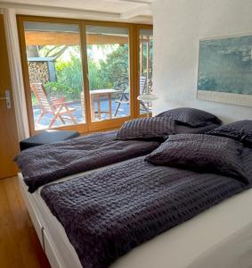 a bedroom with two beds and a view of a patio at B&B Hersberg in Hersberg