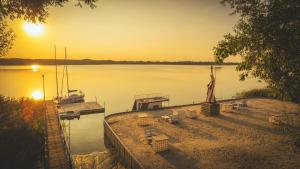 a dock with a statue next to a body of water at Dom Wypoczynkowy "Pod Strzechą" w Giewartowie in Giewartów