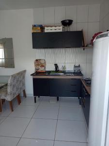 a kitchen with a sink and a table and a chair at Casa com piscina Capitólio in Capitólio