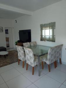 a glass table and chairs in a living room at Casa com piscina Capitólio in Capitólio